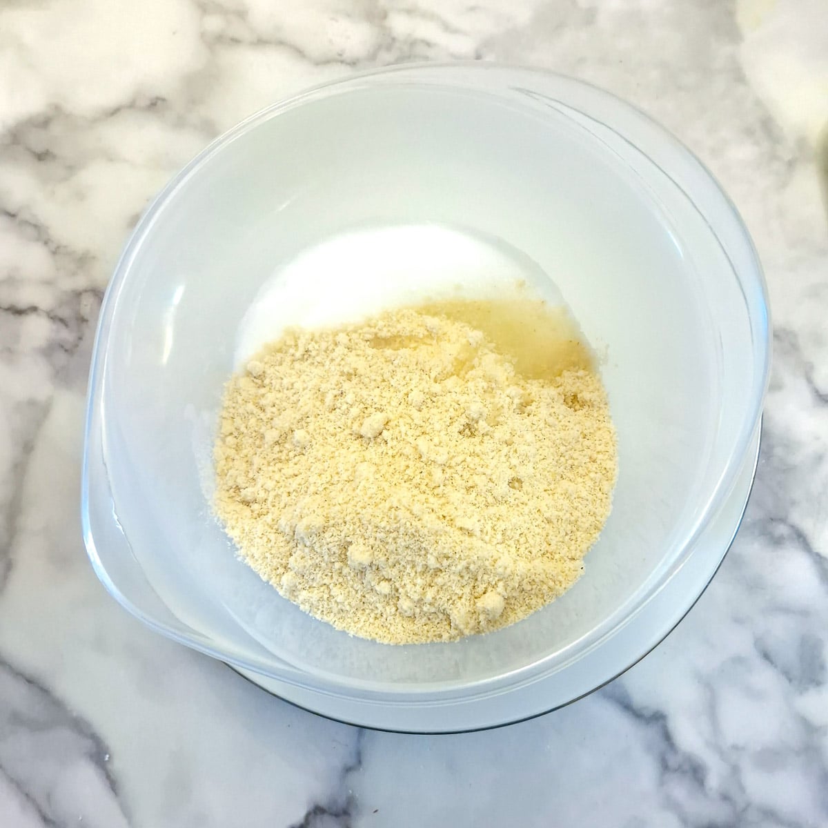 Ground almonds and sugar added to the bowl of egg whites.