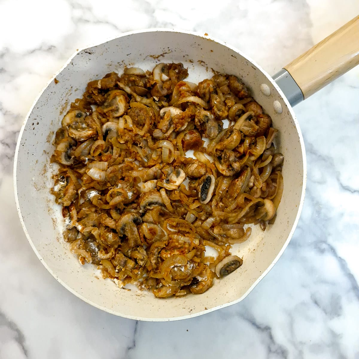 Flour stirred into onions and mushrooms to thicken the stock.