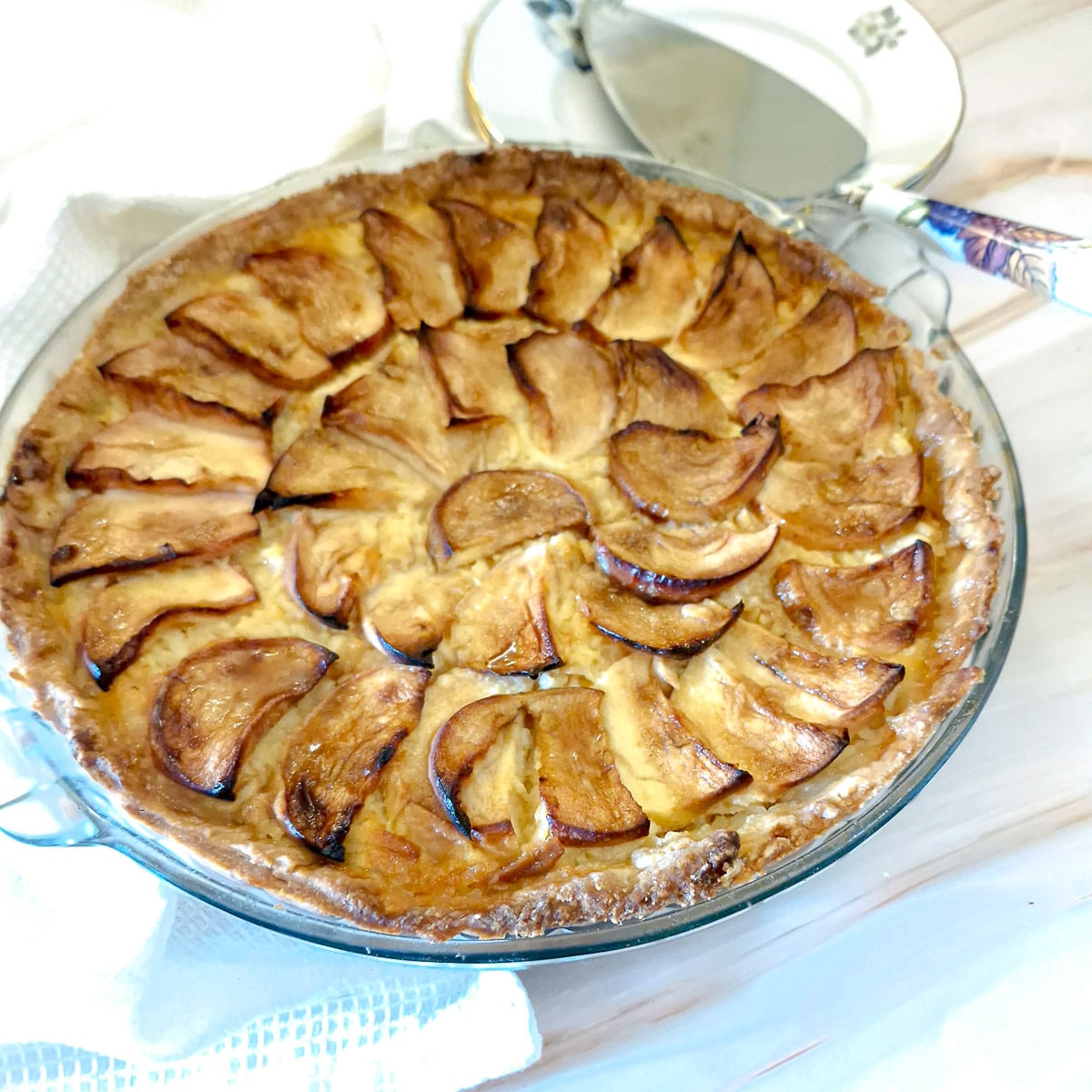 Close up shot of a baked canterbury tart showing the sliced apples on top.