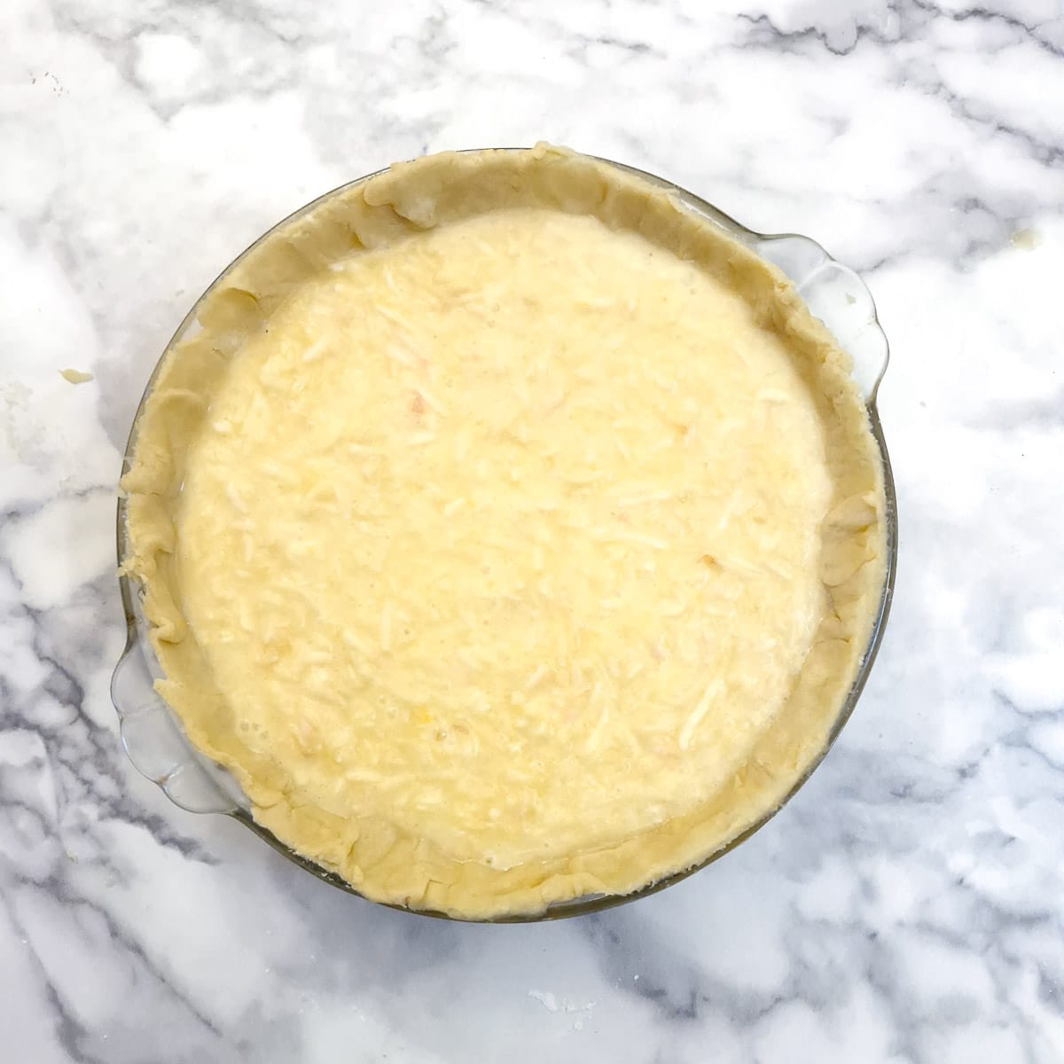 Apple and lemon filling added to the pastry case in a pie dish.