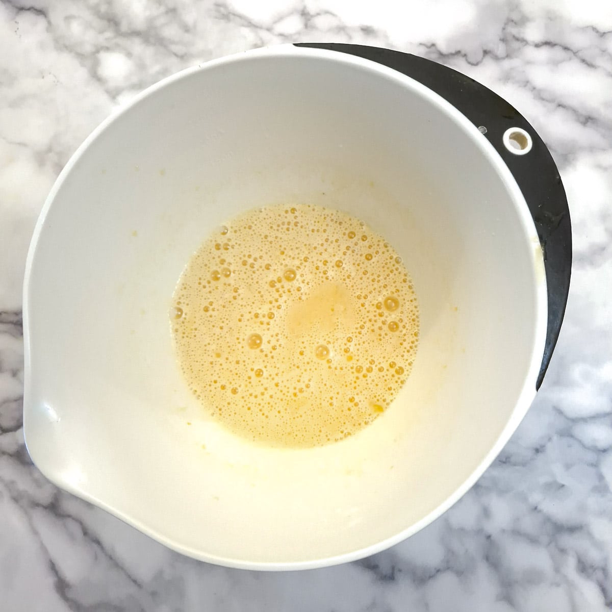 Eggs and sugar combined until frothy in a mixing bowl.