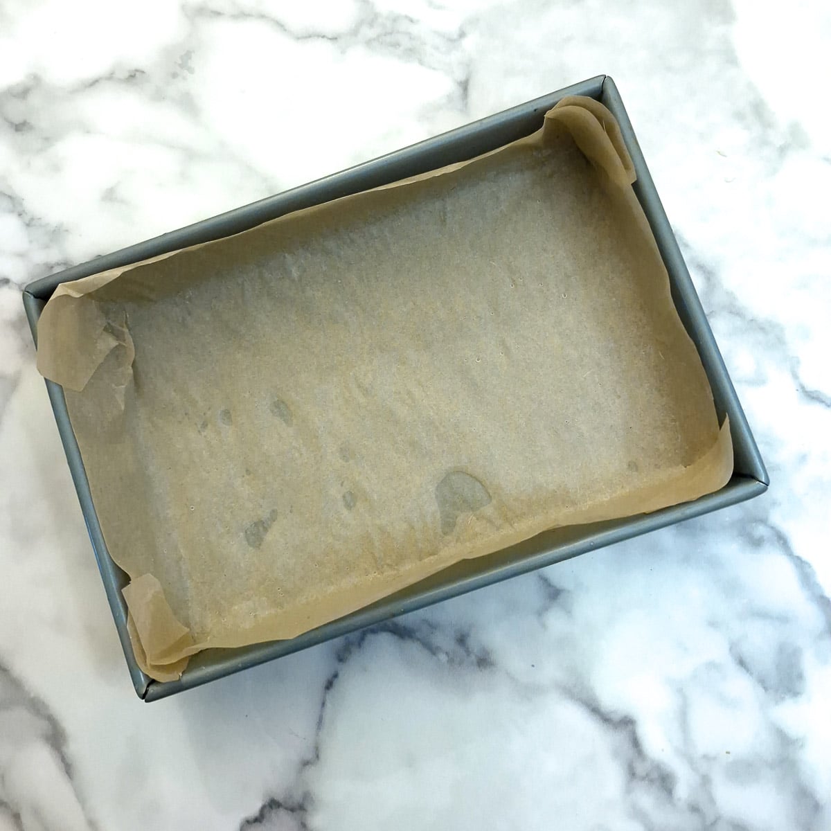 A baking pan lined with baking parchment.