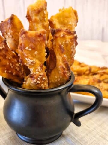 Cheese straws in black jug.