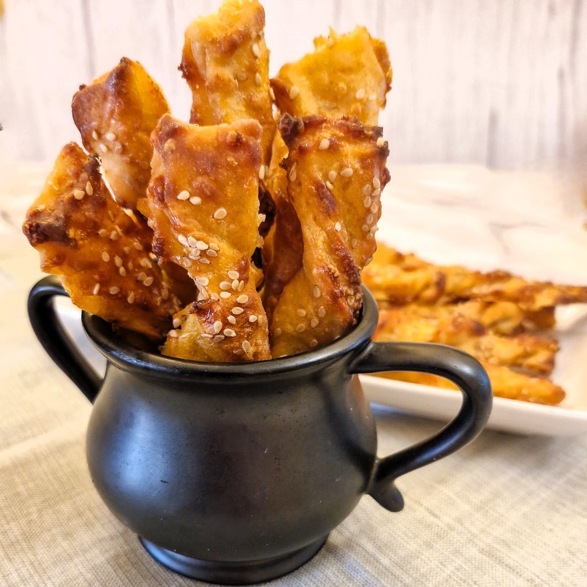 Cheese straws in black jug.