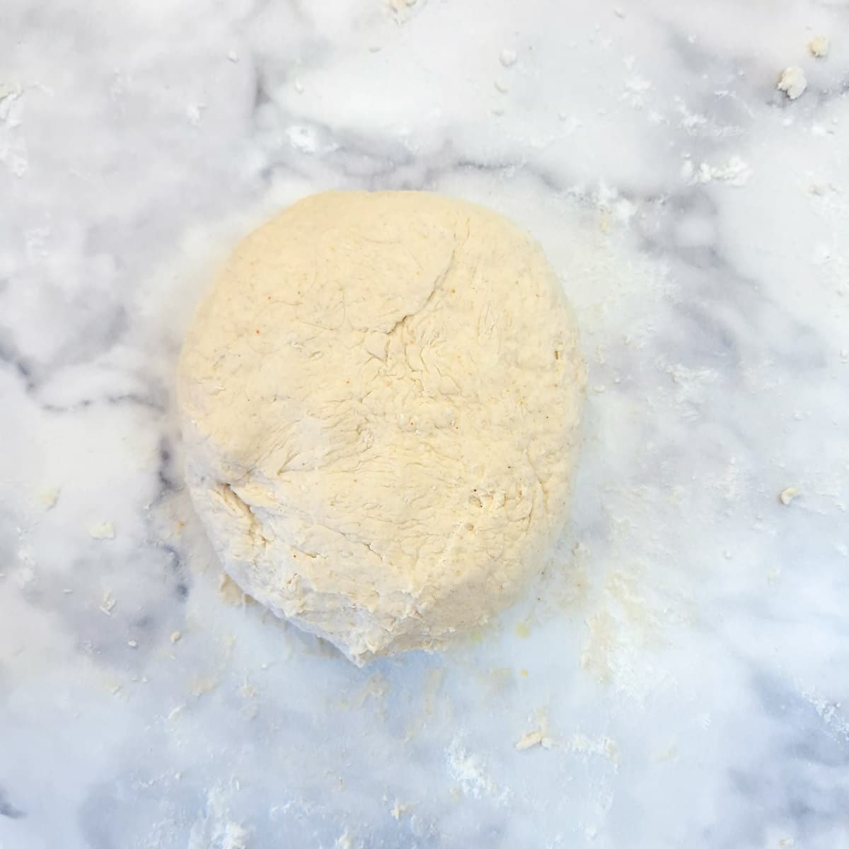 A ball of dough on a floured surface.