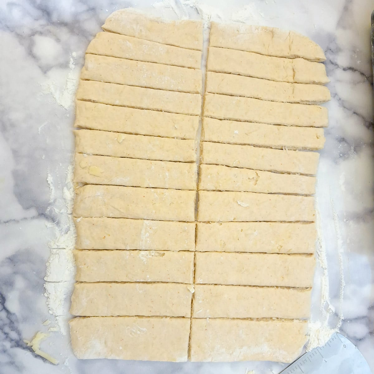 A rectangle of rolled pastry cut into 24 strips.