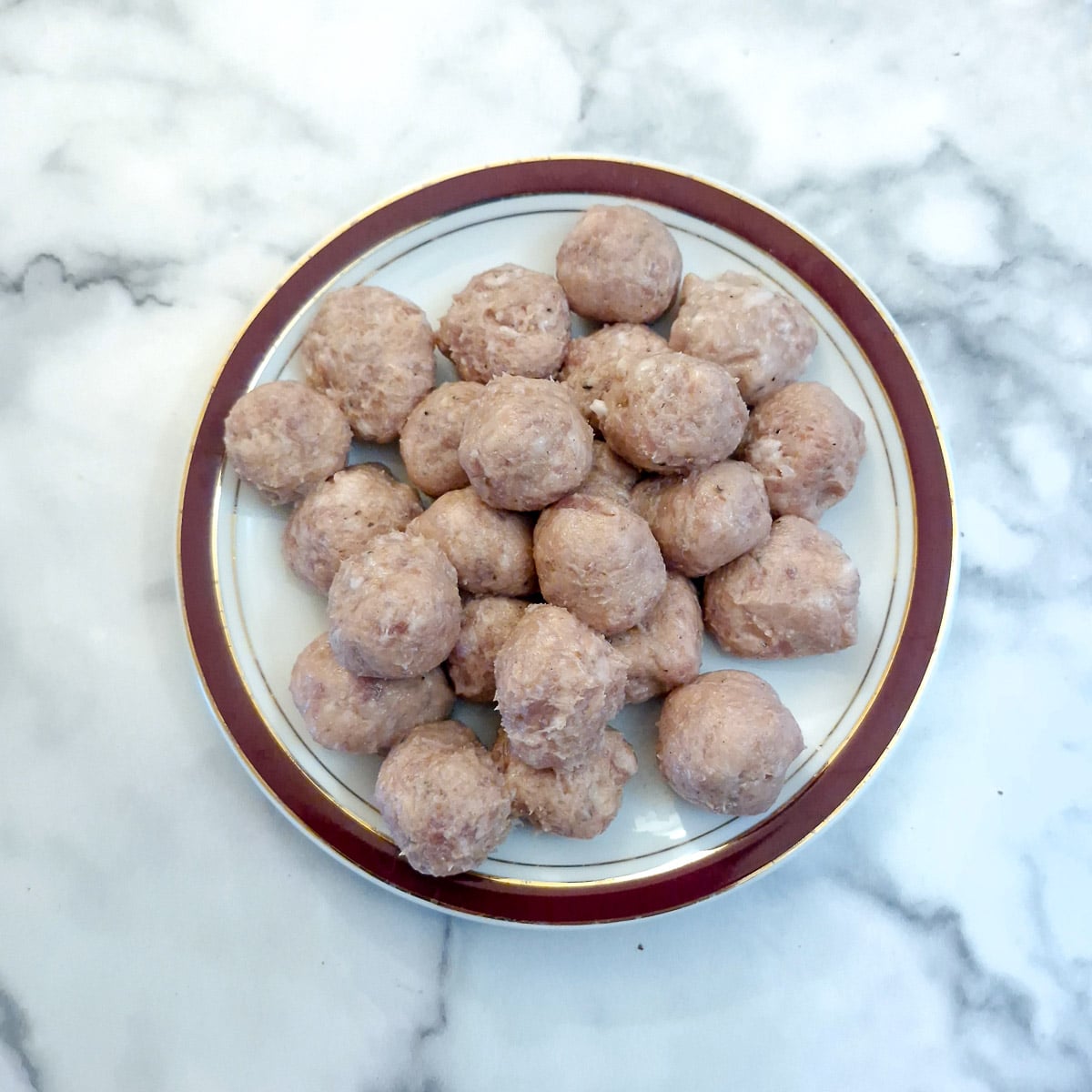 Balls of sausage meat on a plate.