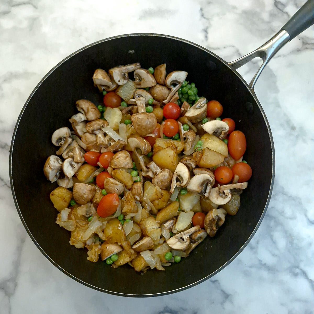 Cherry tomatoes, mushrooms and frozen peas added to the potato hash mixture.