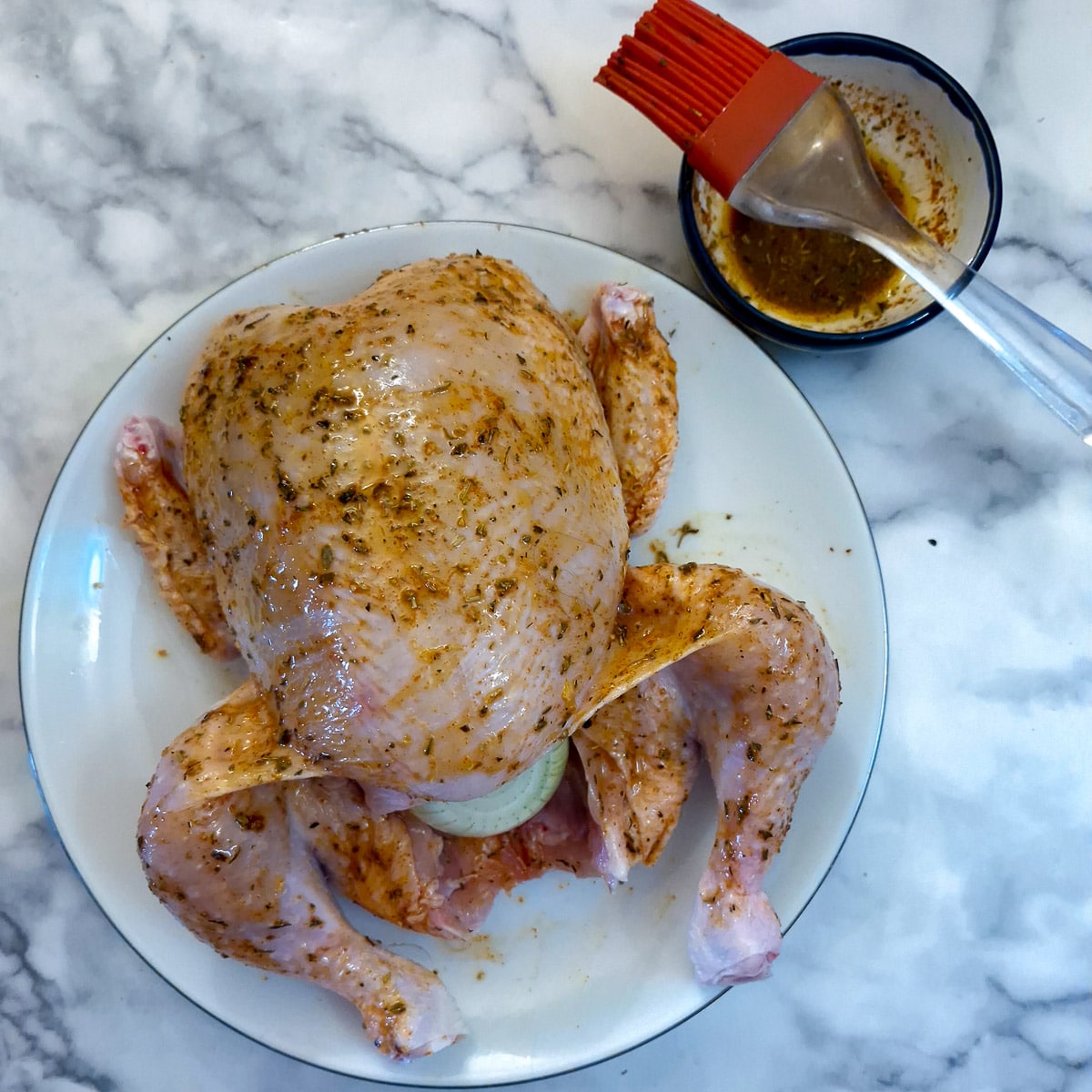A whole chicken brushed with marinade.
