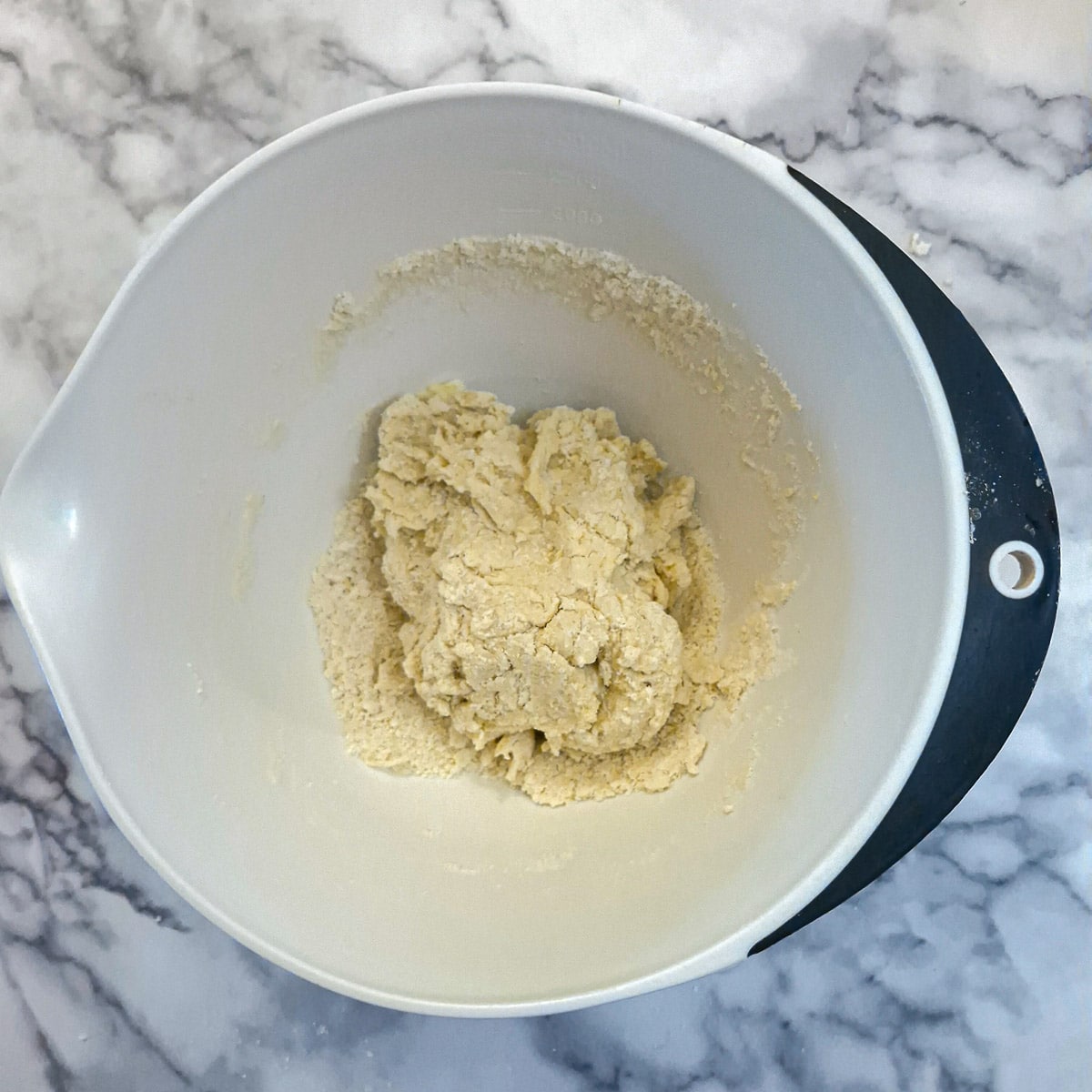 A shaggy ball of dough in a mixing bowl.