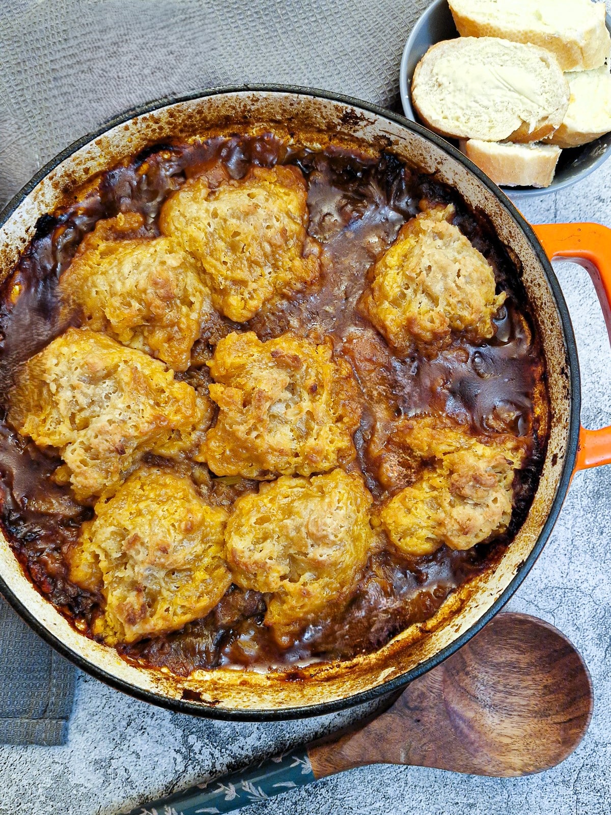 Overhead shot of a dish of beef casserole covered in suet dumplings.