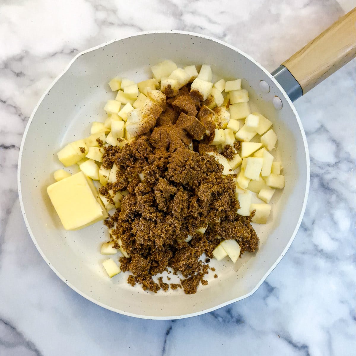 Apples, spices, butter and brown sugar in a frying pan.