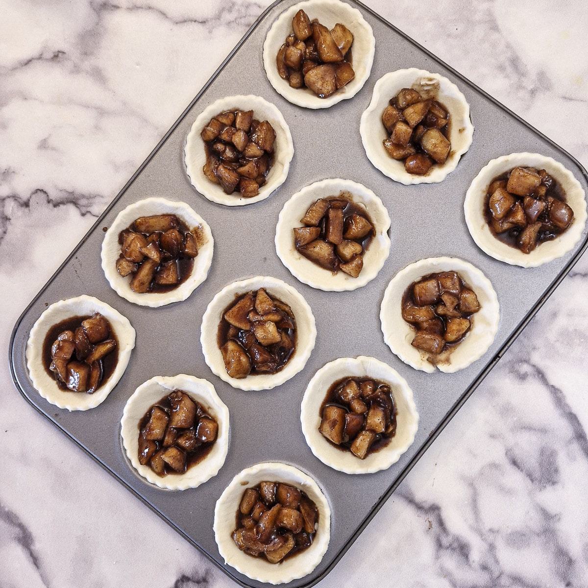 12 pastry cases filled with stewed apples.