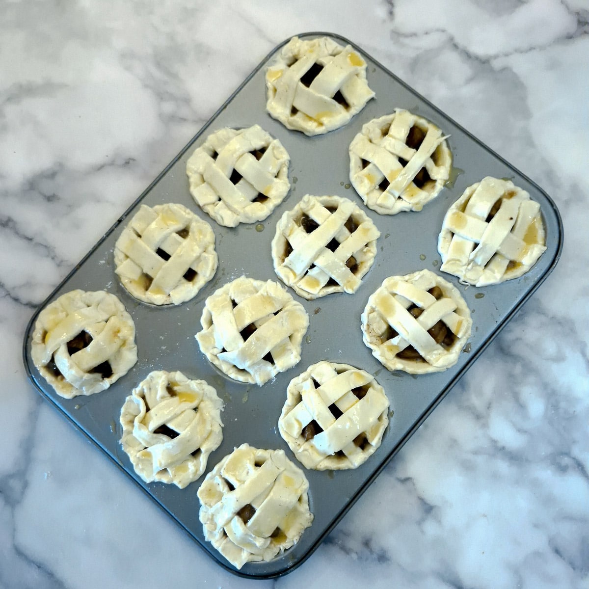 12 apple pies with the pastry lattice in place.