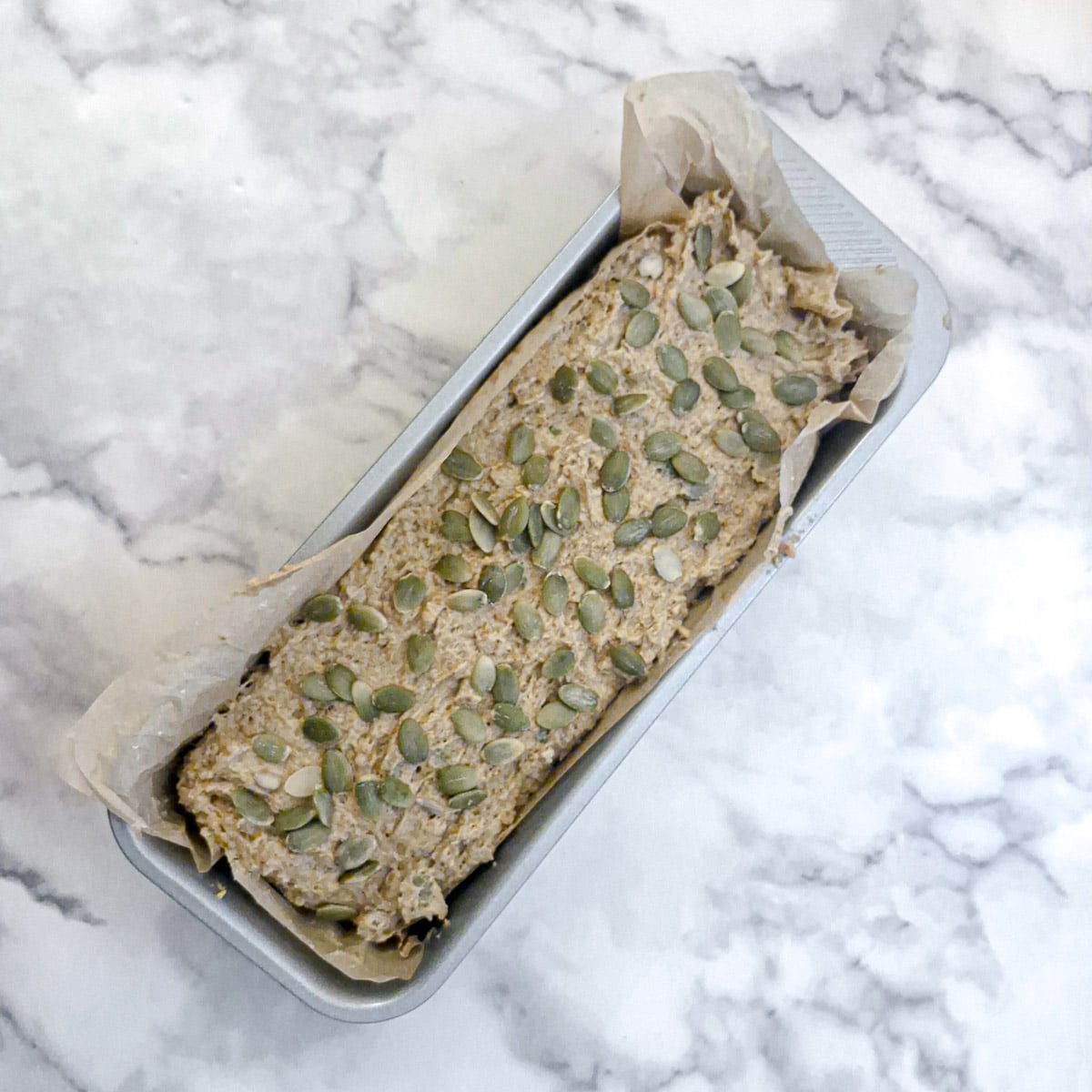 Unbaked dough topped with pumpkin seeds.