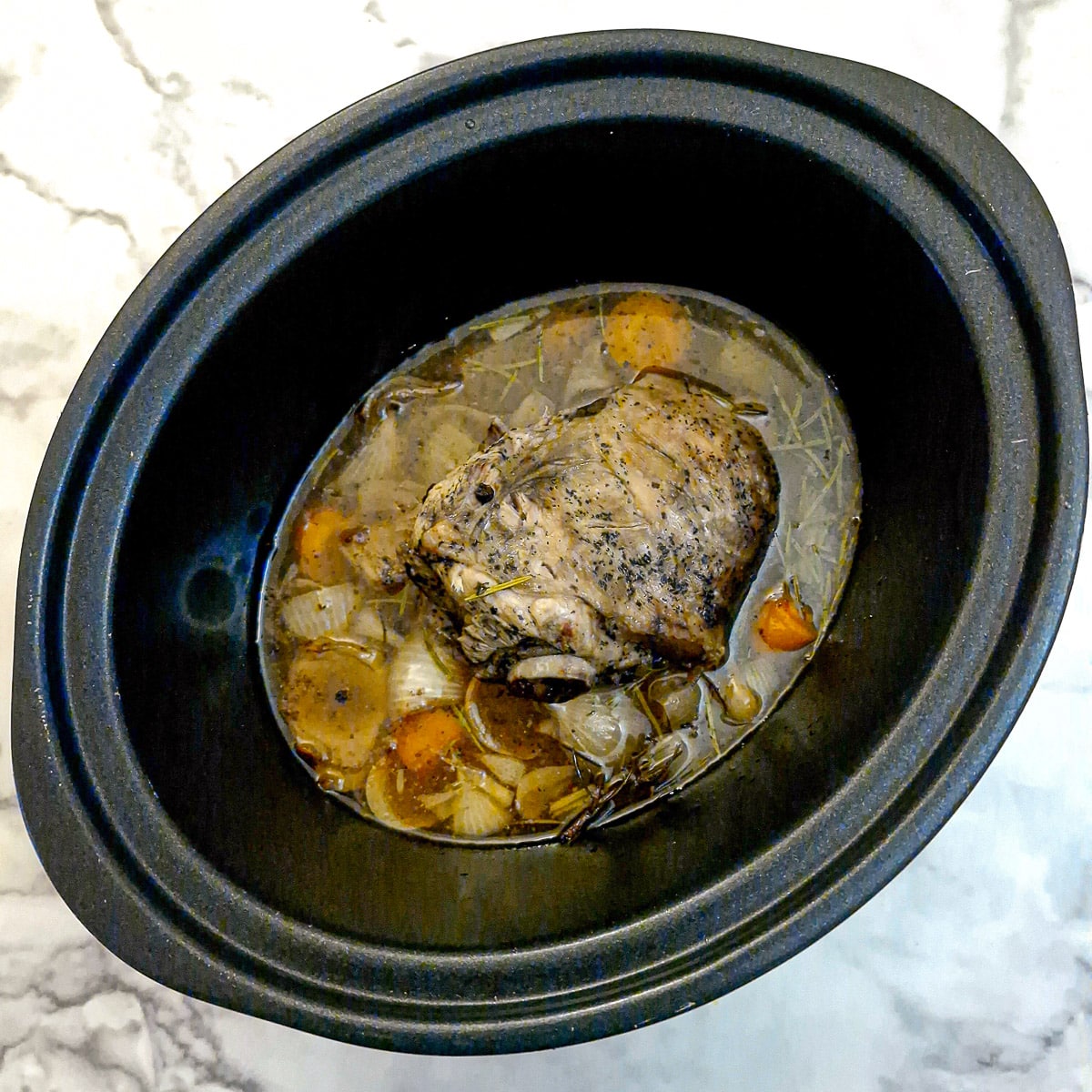 Cooked lamb shoulder in a slow cooker.