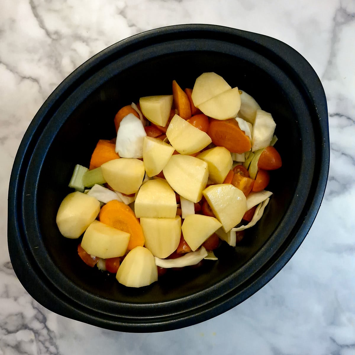 Diced vegetables in a slow cooker.