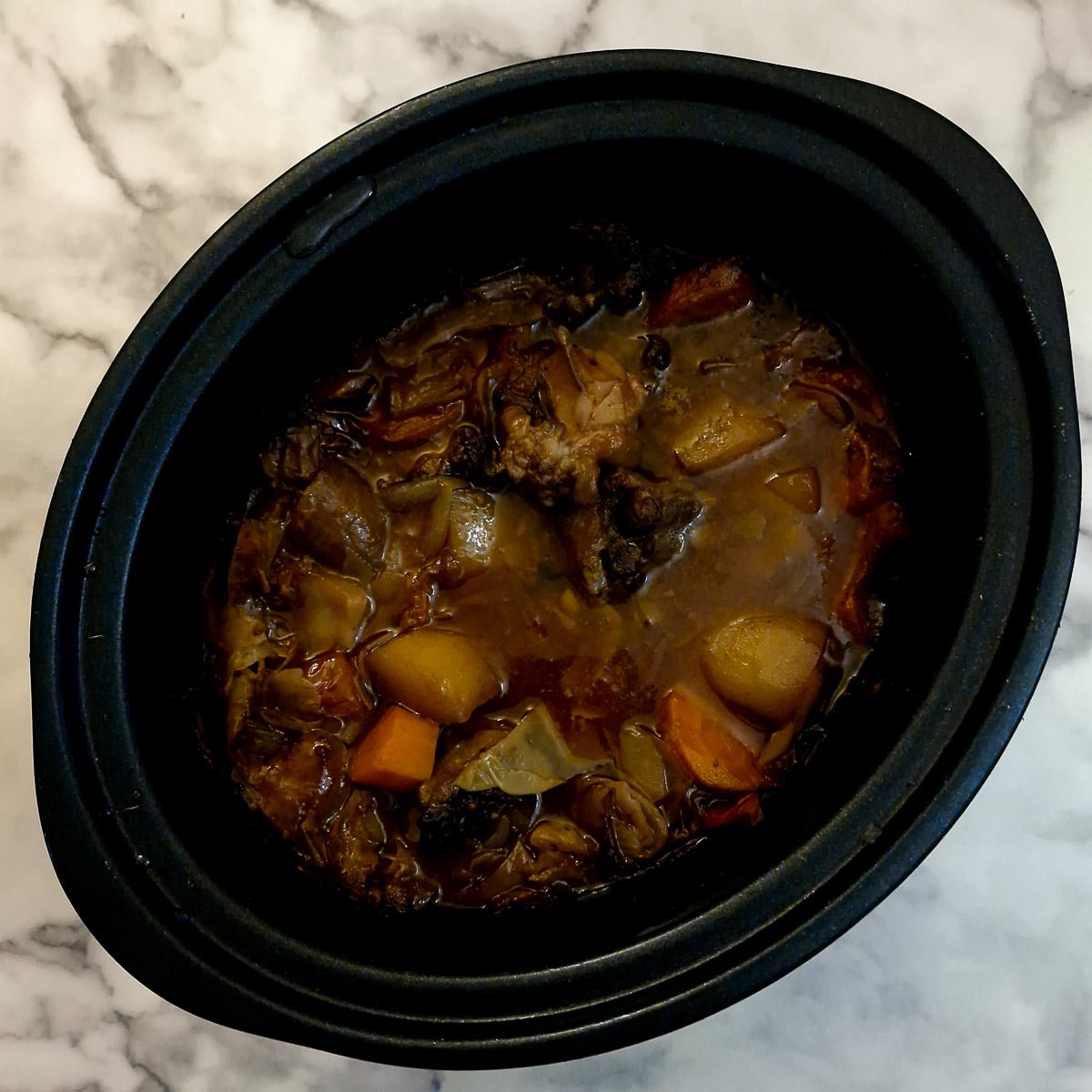 Oxtail stew in a slow cooker after being cooked for 8 hours.