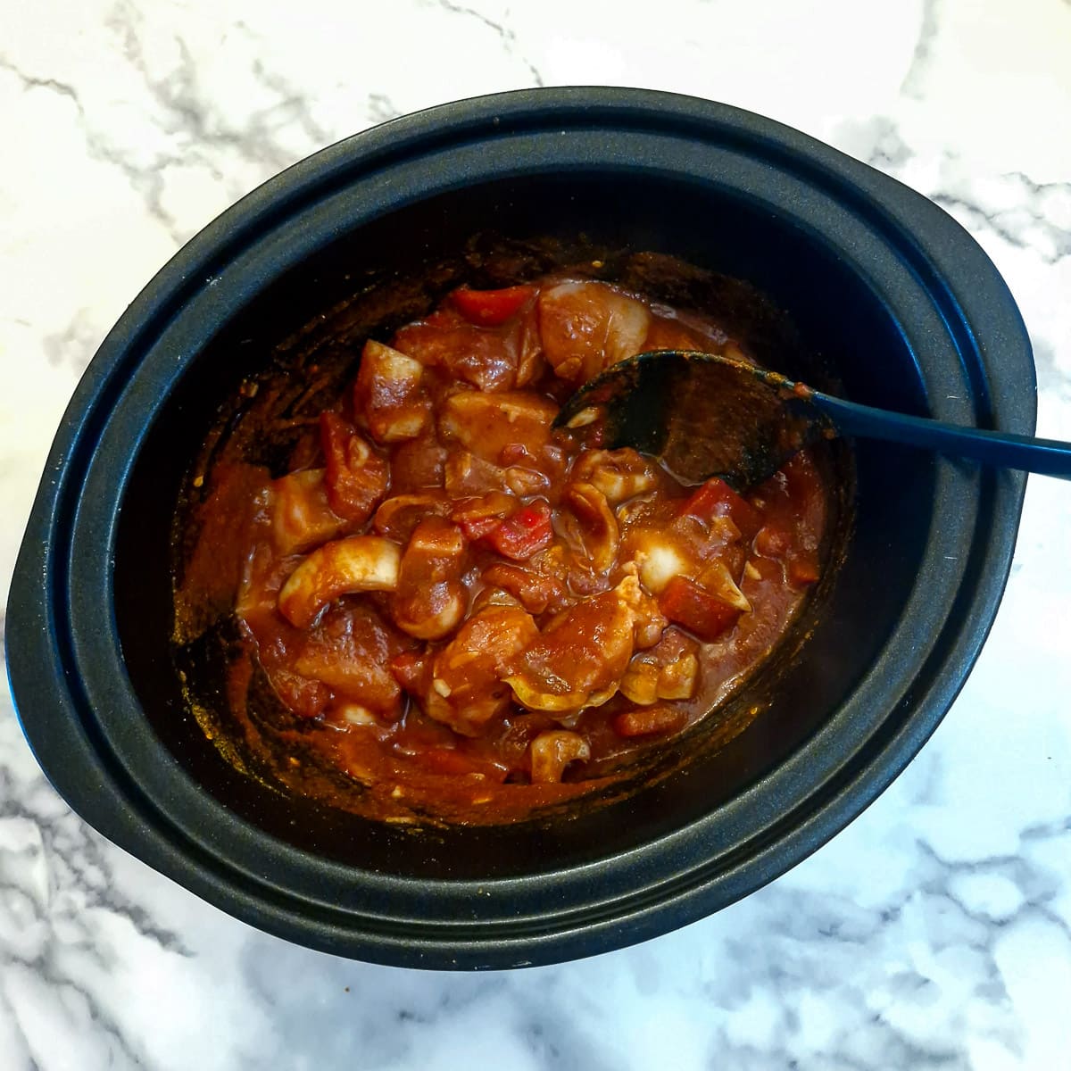 Chicken tikka masala ingredients well combined in a slow cooker.