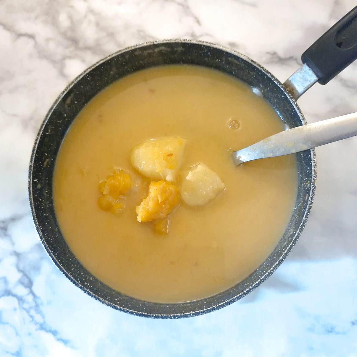 Cooked butternut soup in a saucepan.