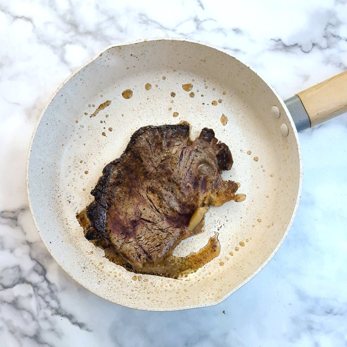 Cooked sirloin steak in a frying pan.