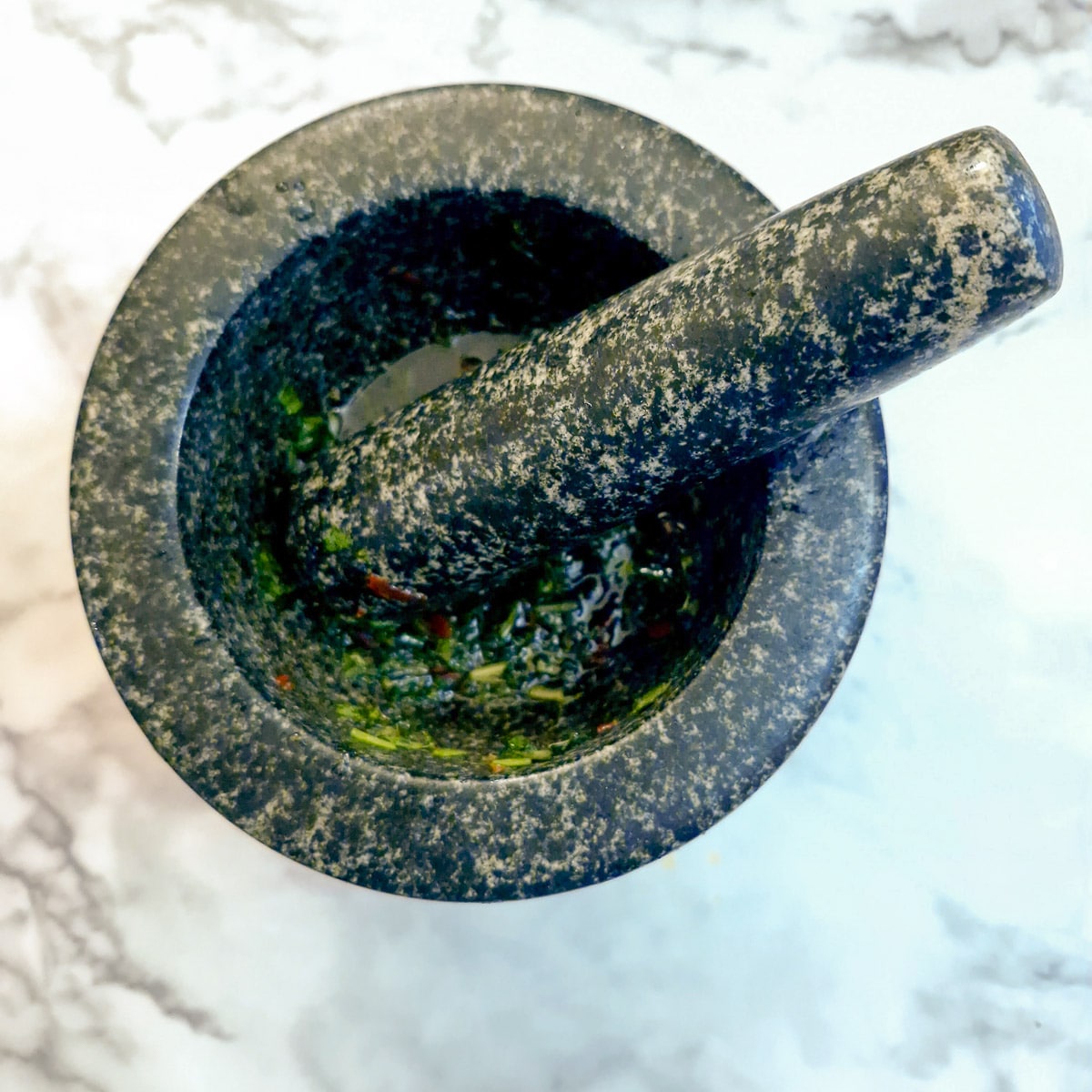 A pestle and mortar with salad dressing.