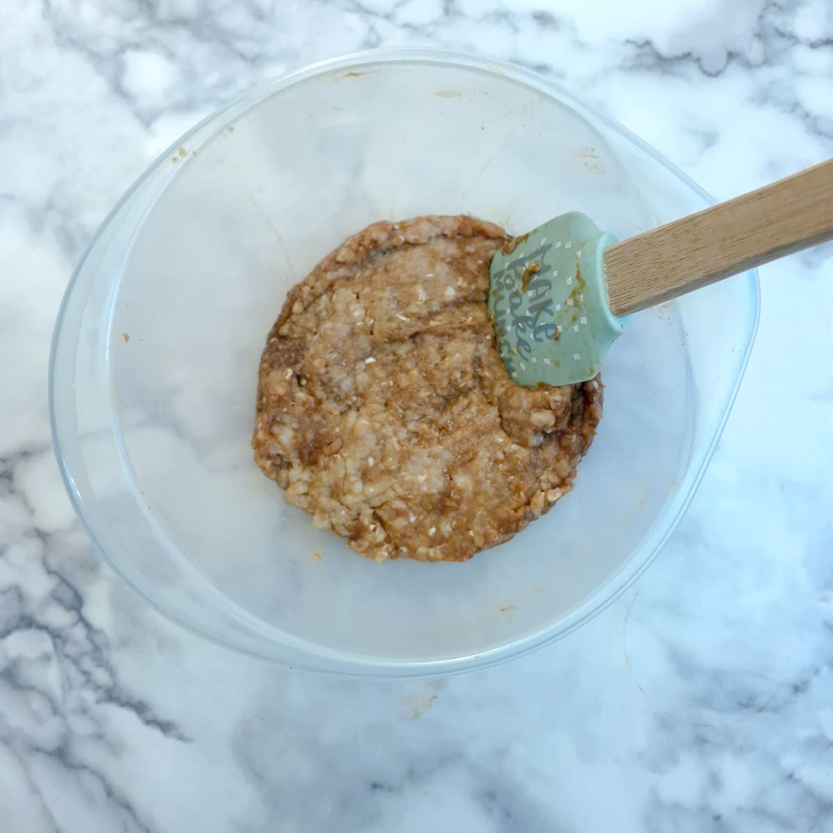 Ground chicken combined with the liquid ingredients.