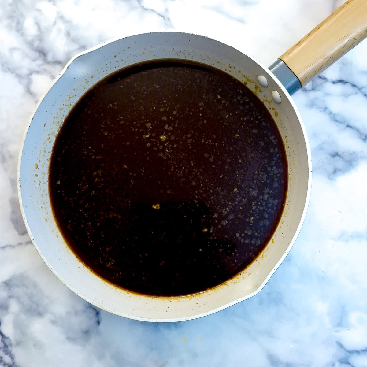 A large frying pan containing sauce ingredients.