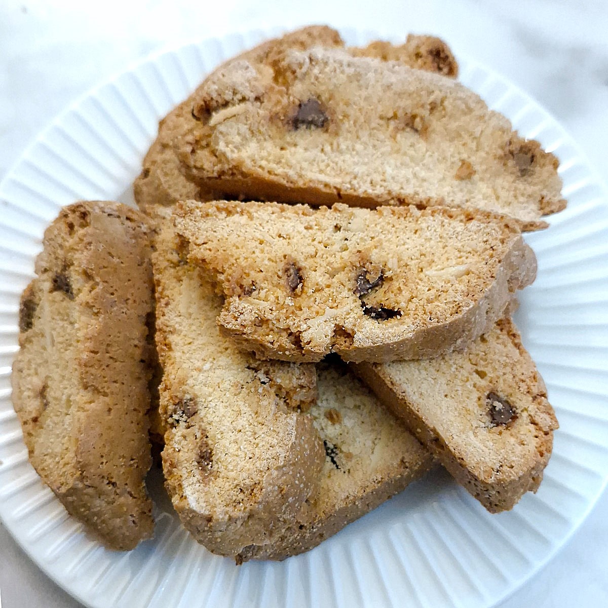 A plate of biscotti flavoured with flaked almonds and chocolate chips.
