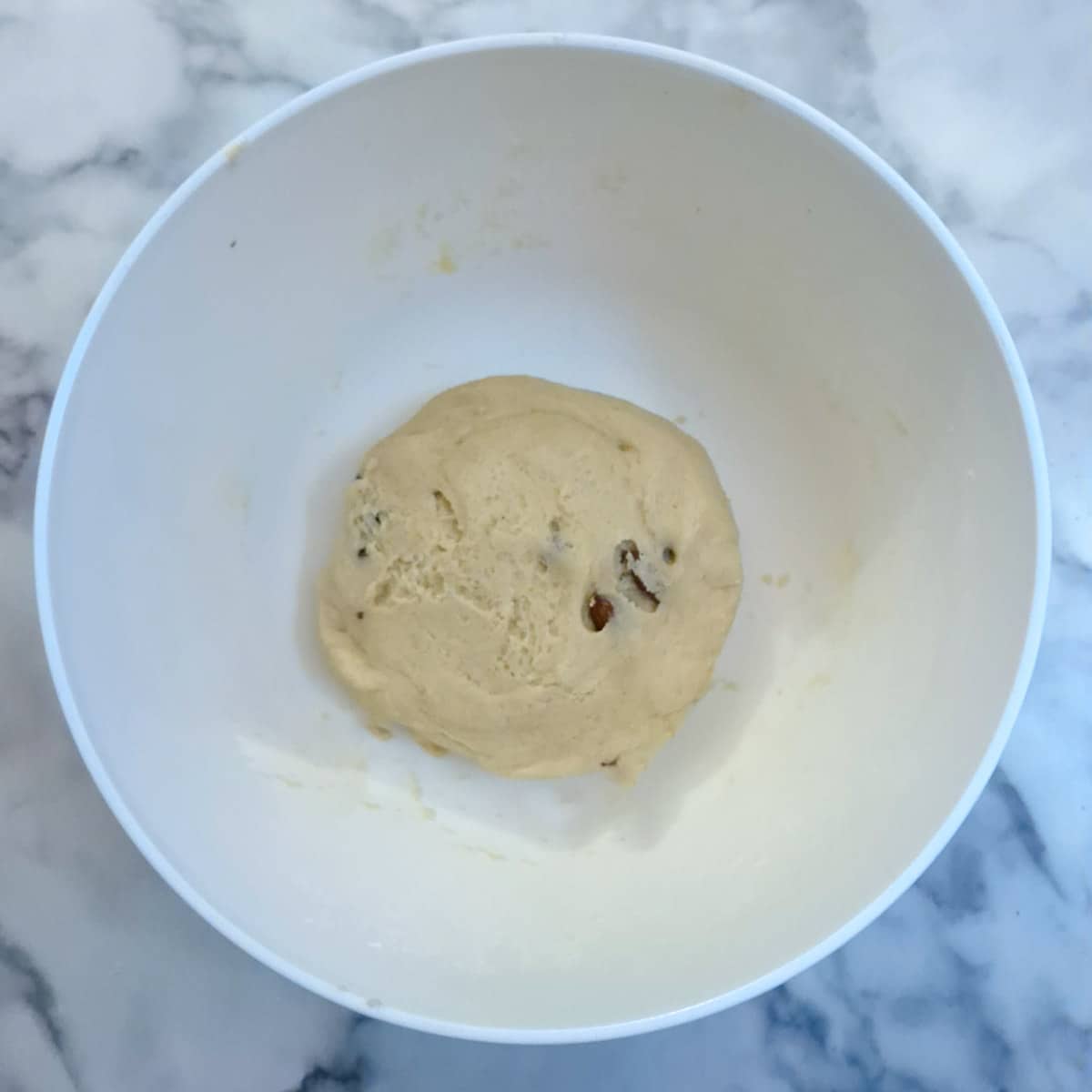 A ball of dough with almonds mixed into it.