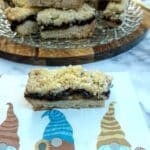 A slice of mince pie crumble of a serviette decorated with three gnomes.