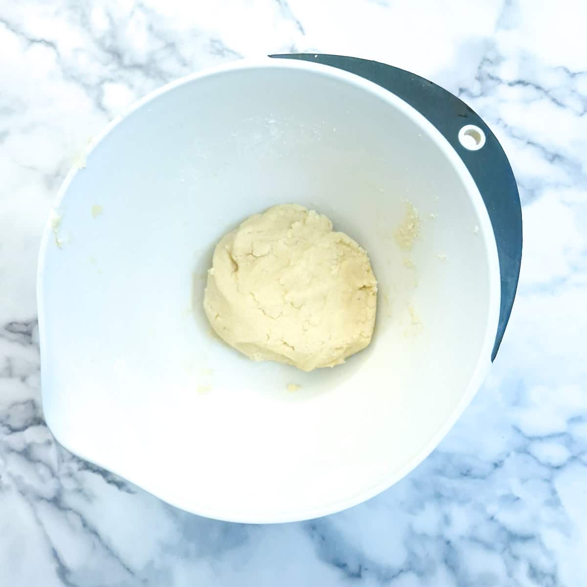 A ball of dough in a mixing bowl.