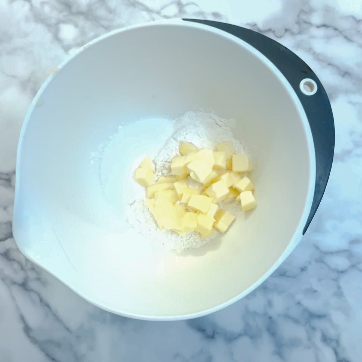 Butter, sugar and flour in a mixing bowl ready to be rubbed into a crumble.