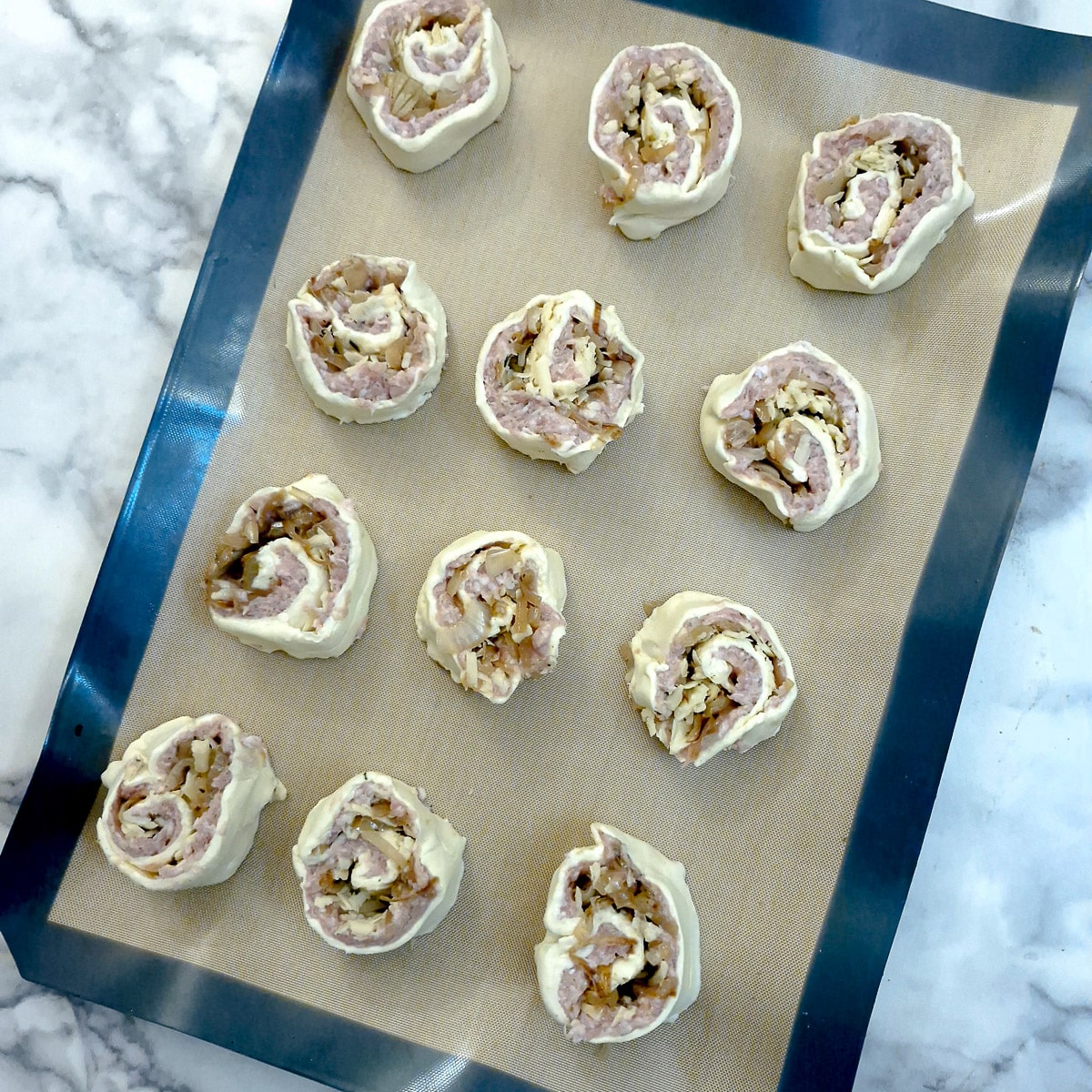 Unbaked pinwheels on a baking tray.