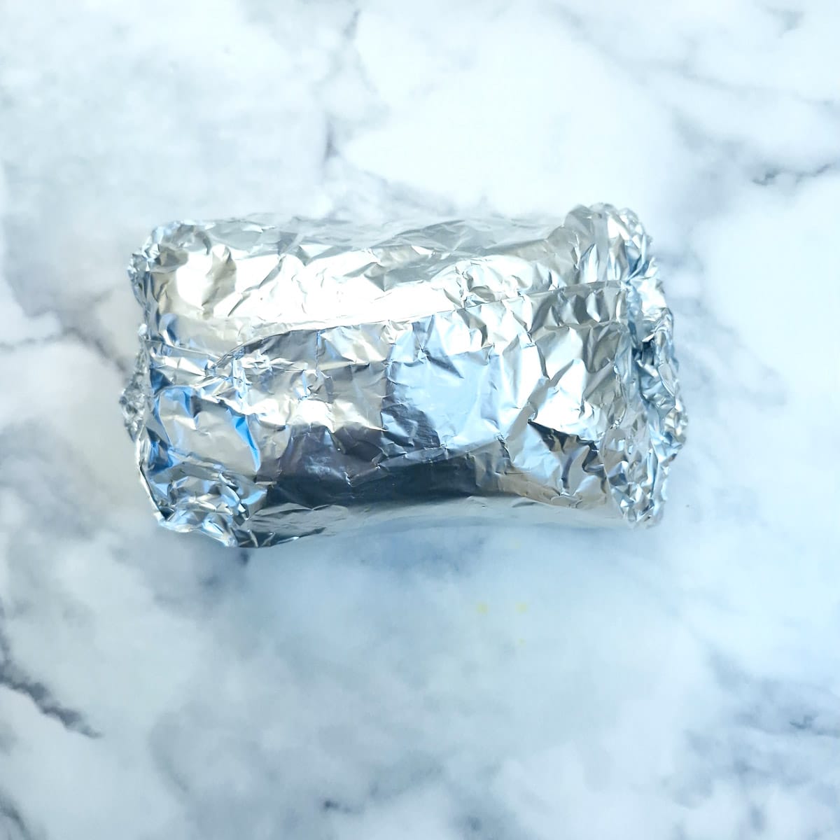 A tin foil-wrapped beef brisket.