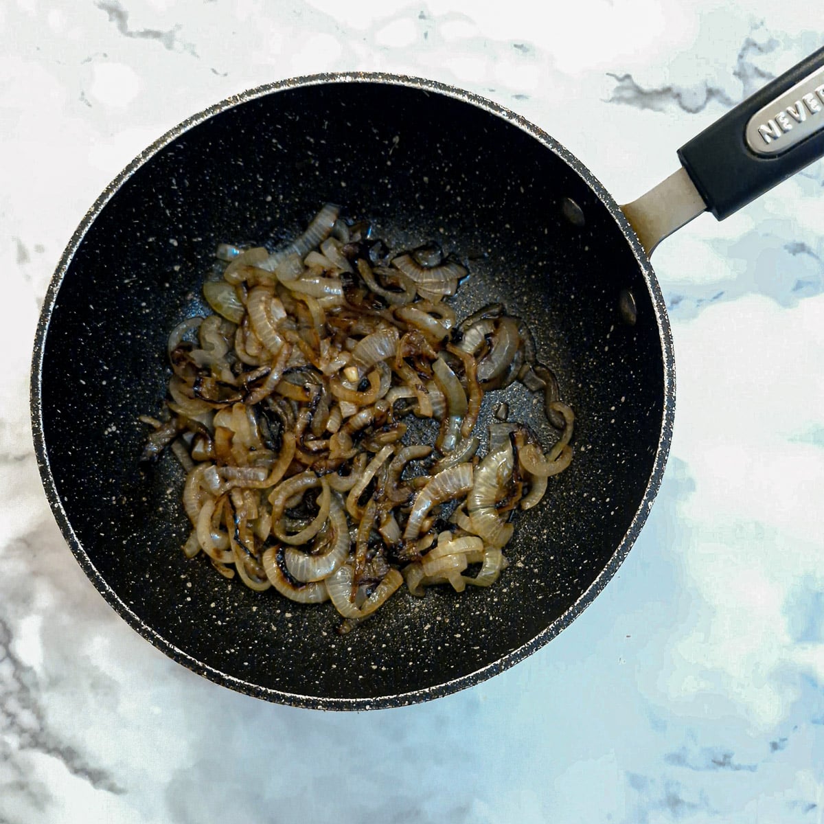 Browned sliced onions in a pan.