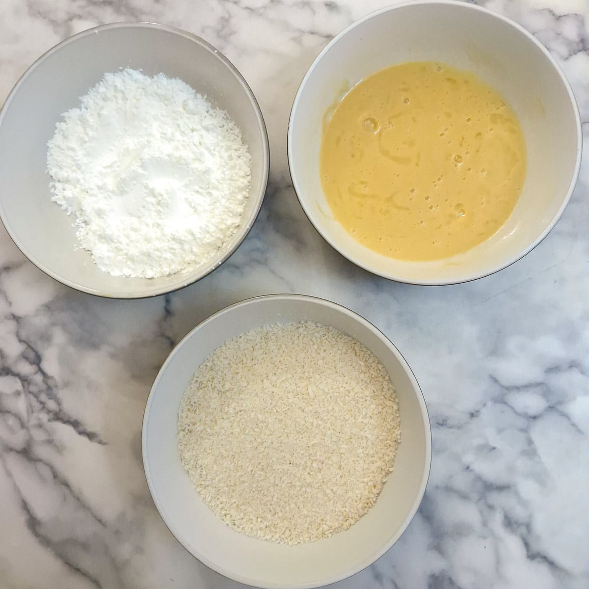 3 bowls, one with cornflour, one with egg and one with breadcrumbs.