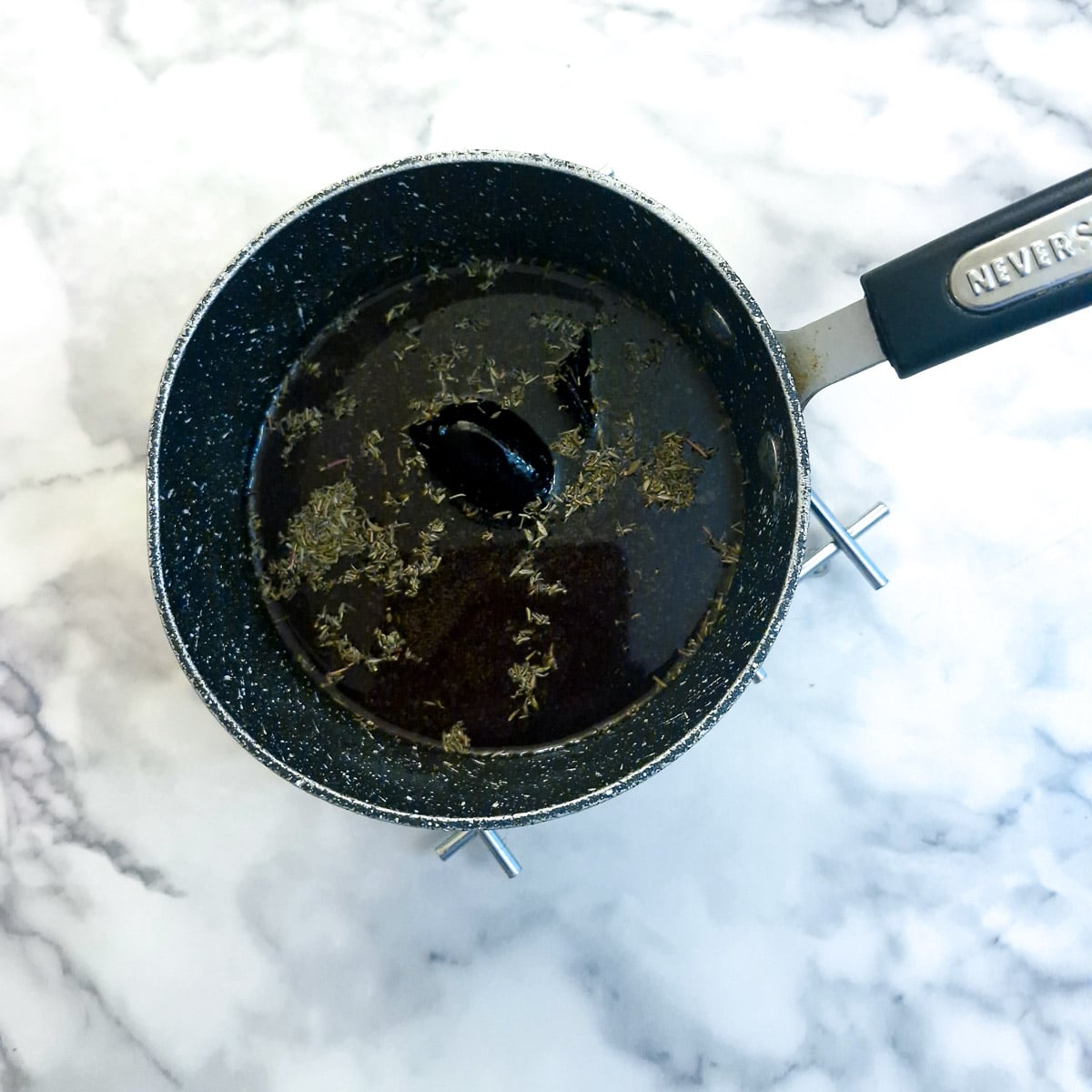 Ingredients for red wine sauce in a saucepan.
