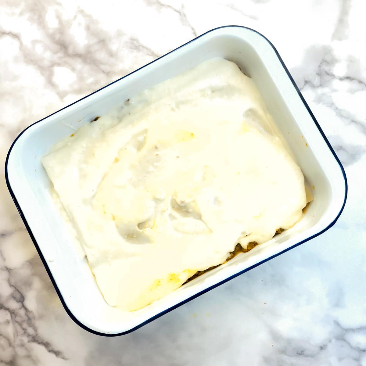A layer of bechamel sauce covering the lasagne sheets.
