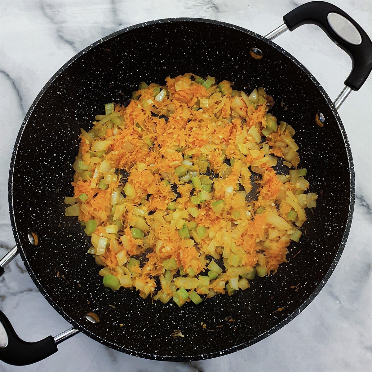 Vegetables for the meat sauce in a frying pan.