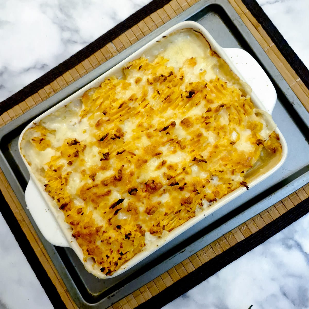 A dish of cooked haddock au gratin with melted cheese on top.