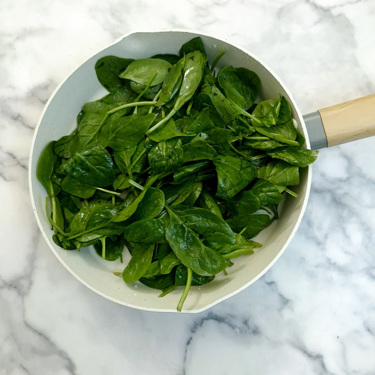 Baby spinach leaves in a saucepan.