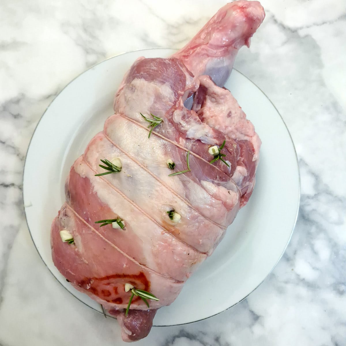 A lamb shoulder joint studded with garlic and rosemary.