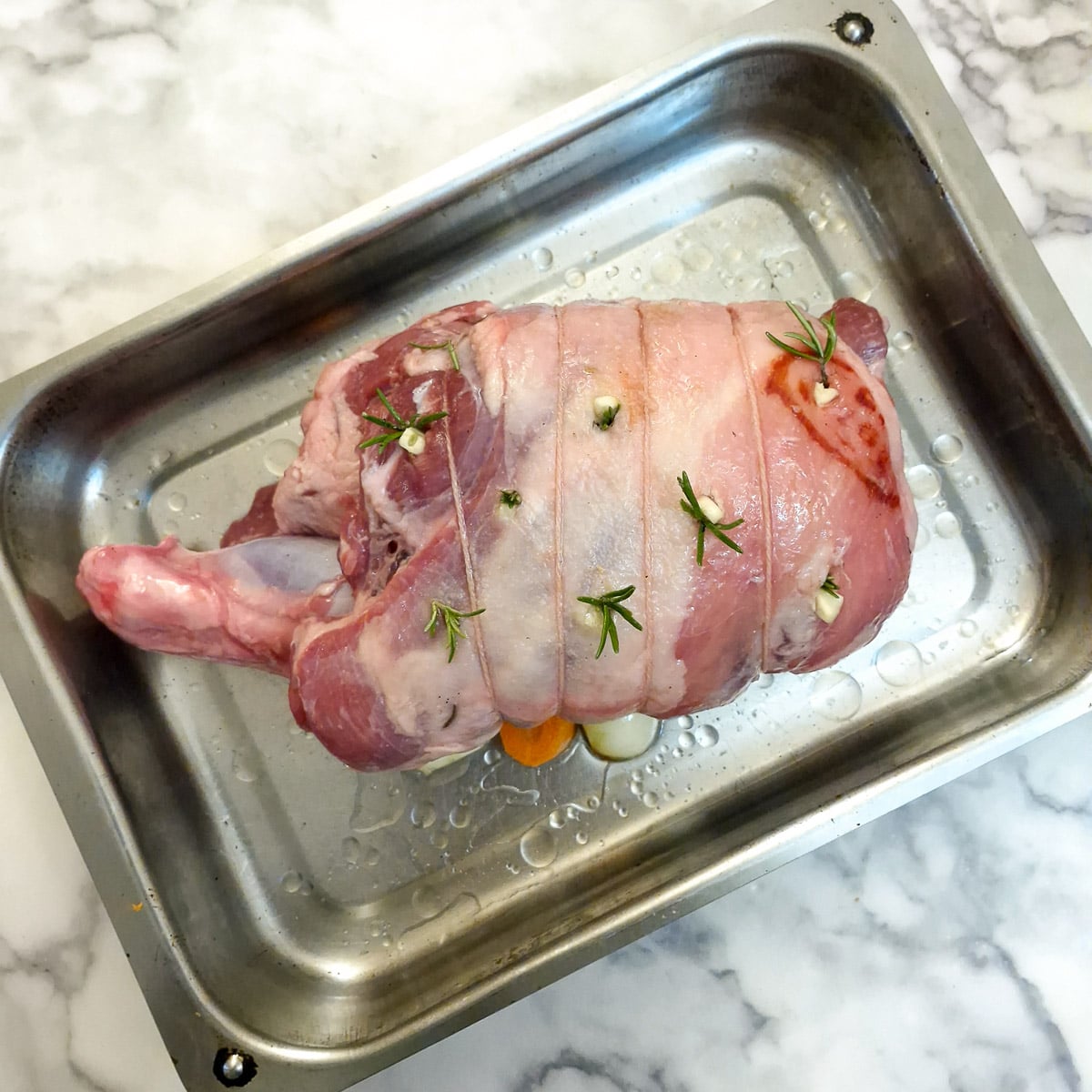 Prepared lamb shoulder in a roasting pan.