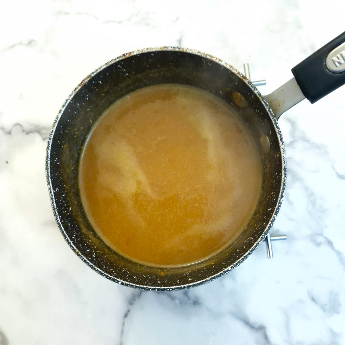 Thickened gravy in a saucepan.