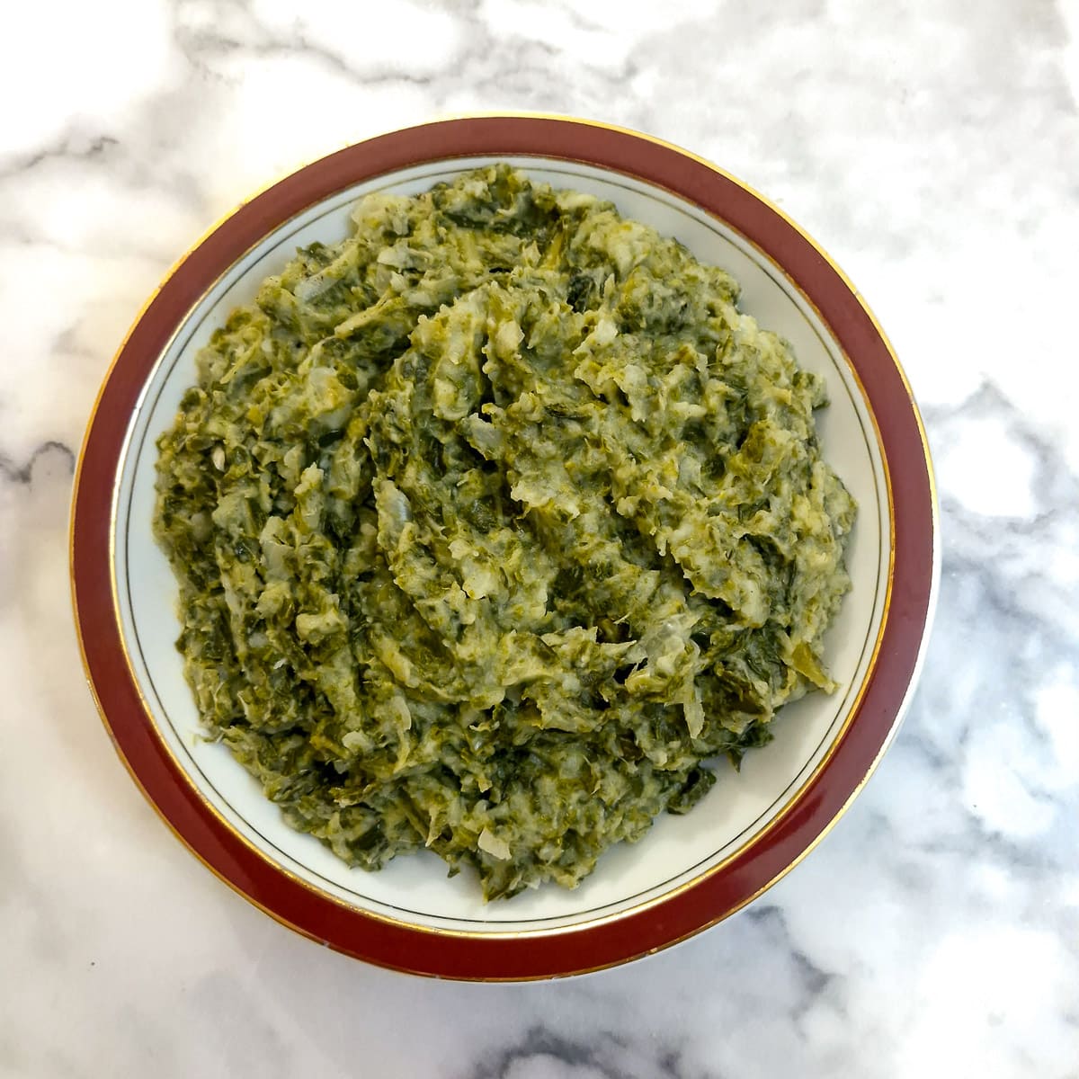 Spring greens in a red-rimmed serving dish.