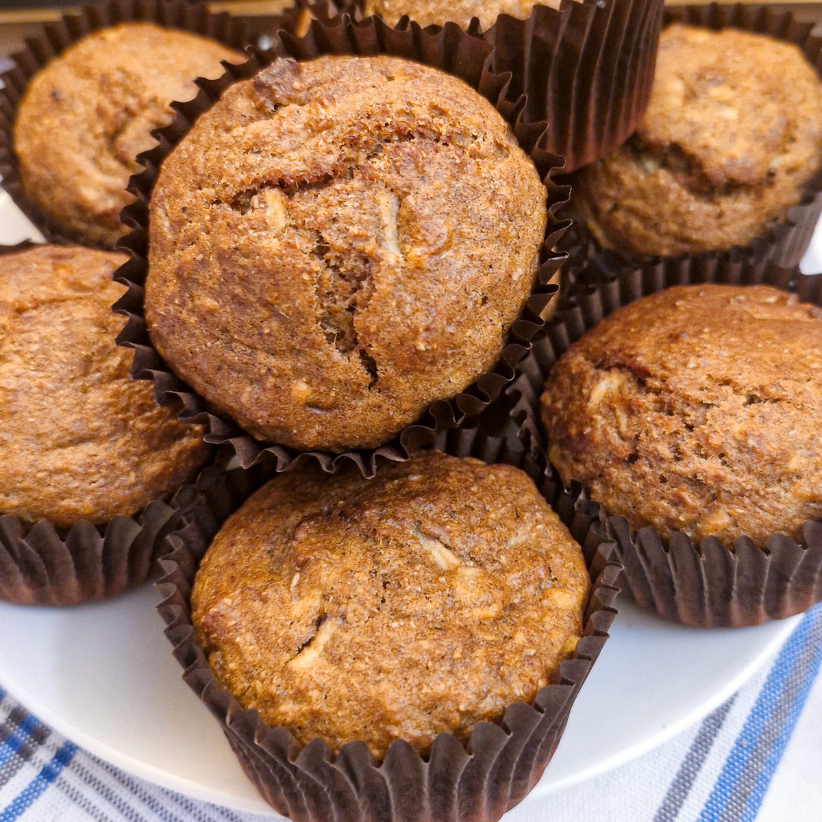 A pile of honey bran muffins on a white plate.
