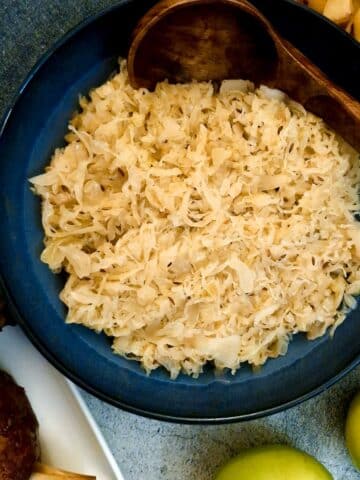 Sauerkraut with apples in a blue serving dish.