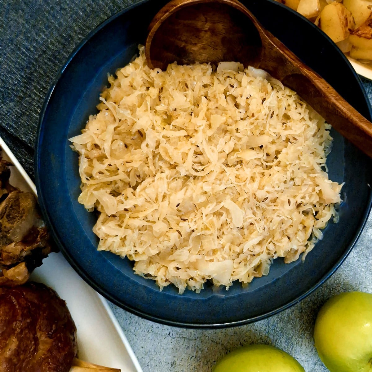 Sauerkraut with apples in a blue serving dish.