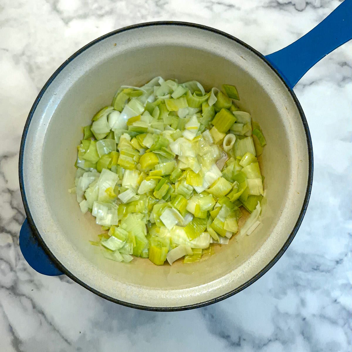 Softened leeks in a saucepan.
